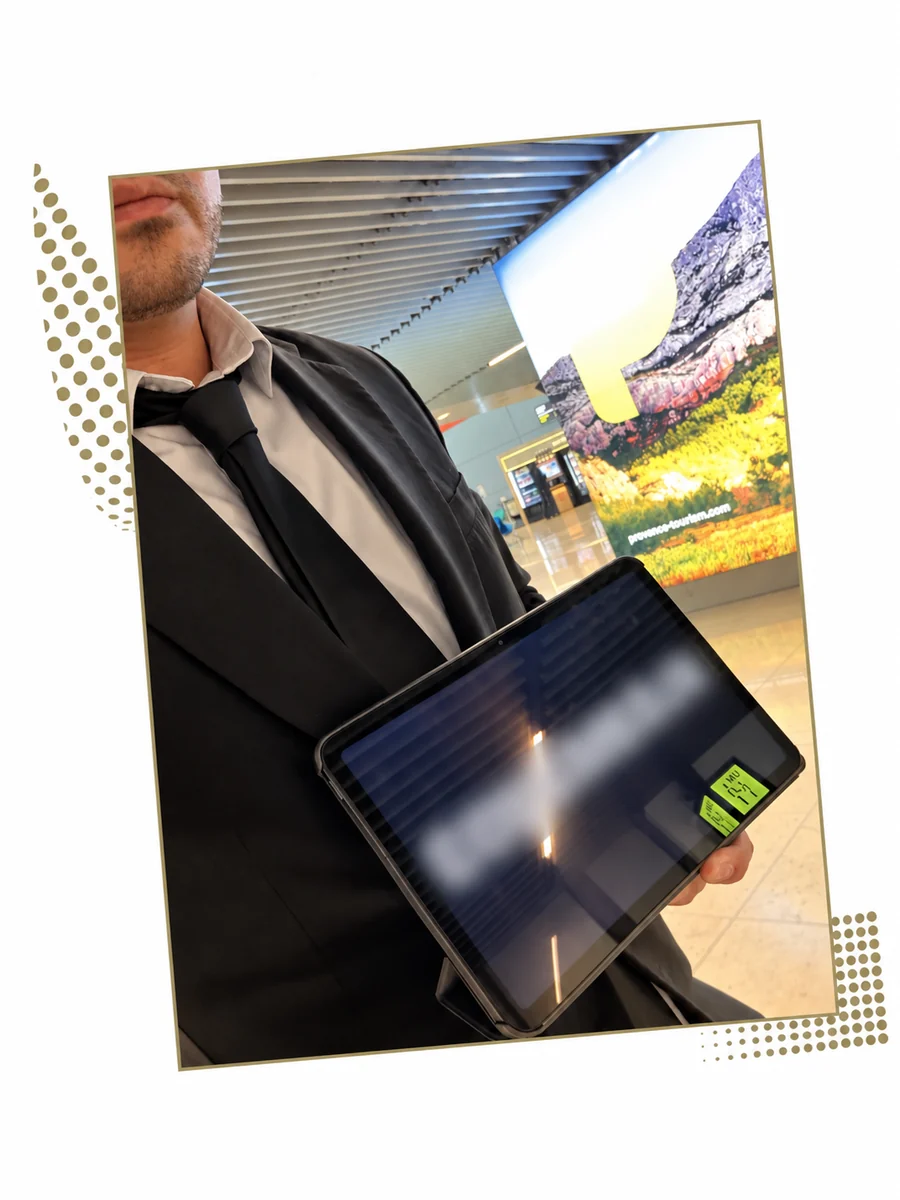 Chauffeur en costume tenant une tablette d’accueil dans un terminal