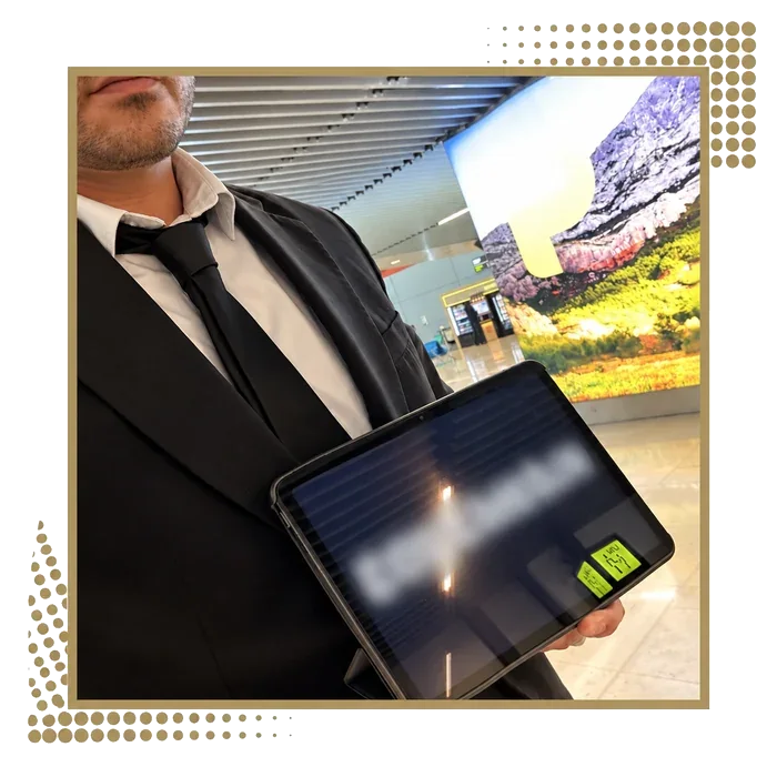 Driver in a suit holding a docking station tablet in a terminal