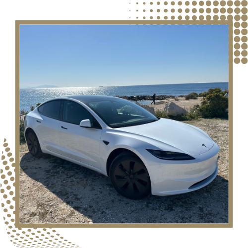 Tesla Model 3 blanche stationnée en bord de mer