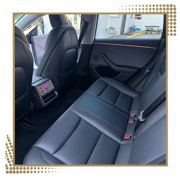 Banquette arrière et écran passager d’une Tesla Model 3