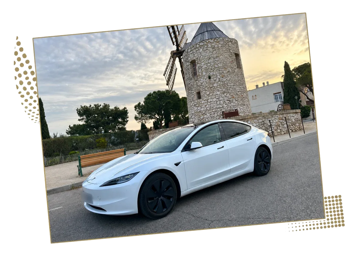 White Tesla Model 3 in front of a stone windmill